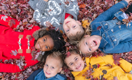 Children lying in leaves